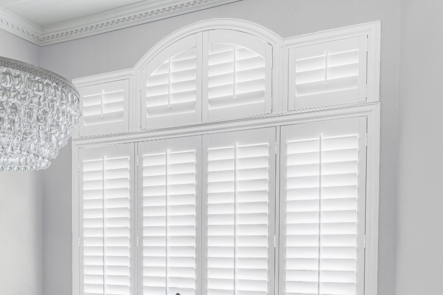 Plantation shutters covering windows in dining room.